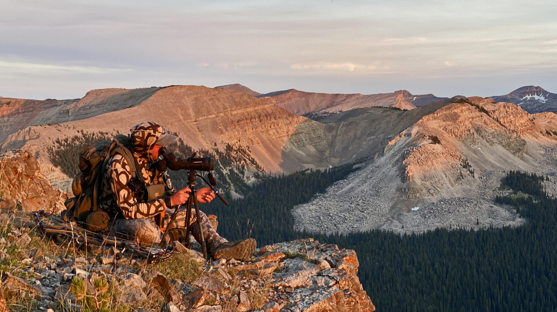 Hunter on Mountain Glassing with Spotting Scope for Bighorn Sheep 